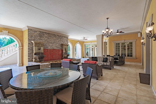 dining space featuring a textured ceiling, ceiling fan, crown molding, and decorative columns