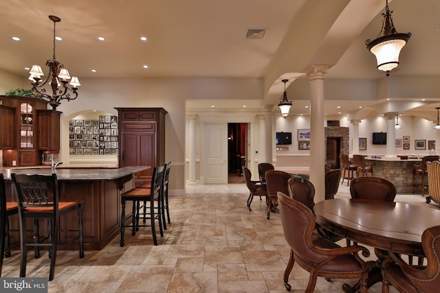 dining area featuring a chandelier and decorative columns