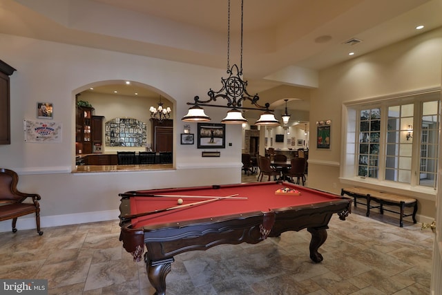 recreation room with pool table, a towering ceiling, and a notable chandelier