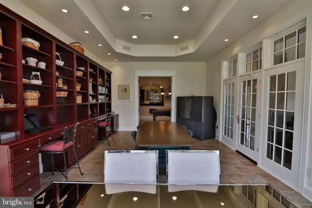 tiled home office with french doors, built in desk, billiards, and a raised ceiling