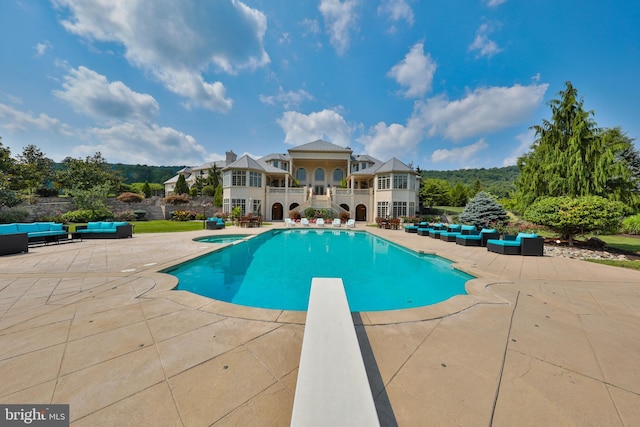 view of pool featuring a diving board, a patio, and an outdoor living space