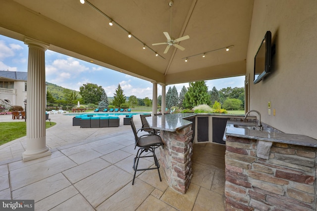 view of patio featuring a wet bar and ceiling fan