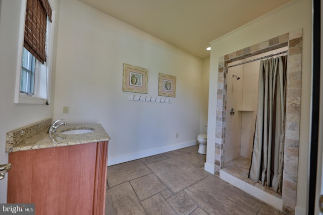 bathroom with toilet, vanity, and curtained shower