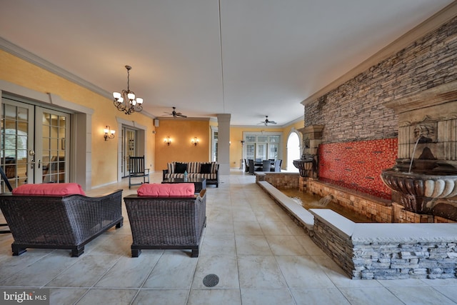 interior space featuring ceiling fan with notable chandelier, light tile patterned floors, crown molding, decorative columns, and french doors