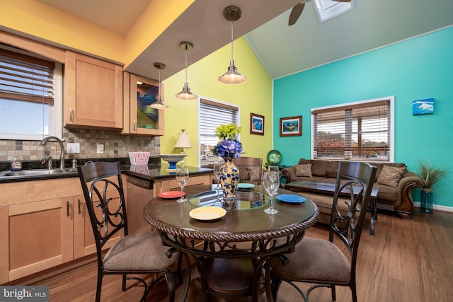 dining room with plenty of natural light, dark wood-type flooring, lofted ceiling, and sink