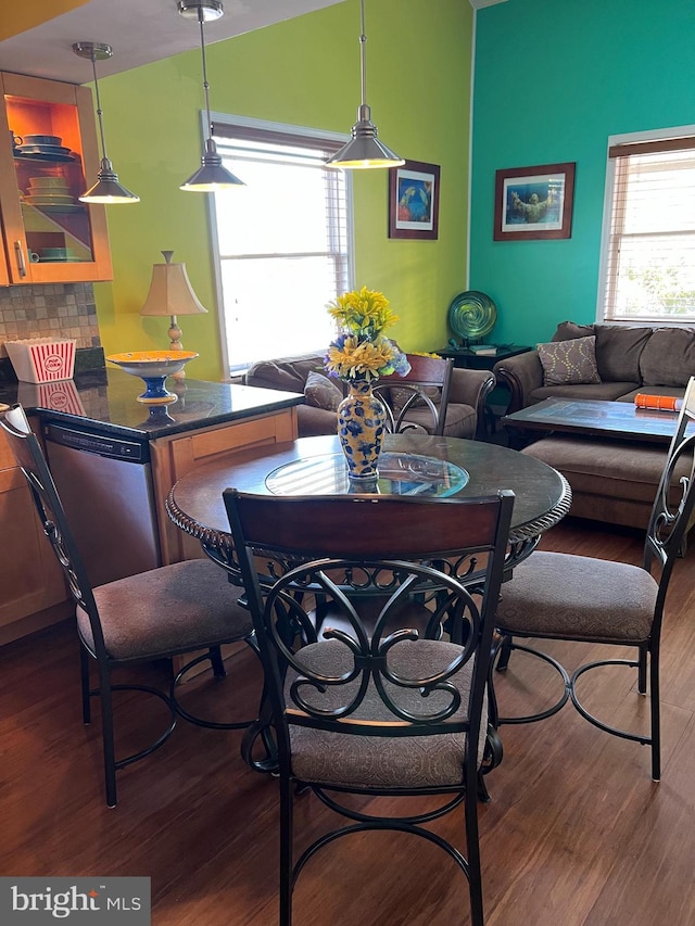 dining space featuring wood-type flooring and vaulted ceiling