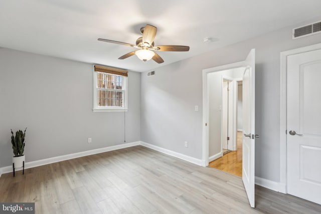 unfurnished bedroom featuring light wood-style flooring, baseboards, visible vents, and ceiling fan