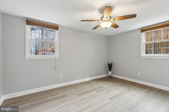 empty room featuring ceiling fan, baseboards, and wood finished floors