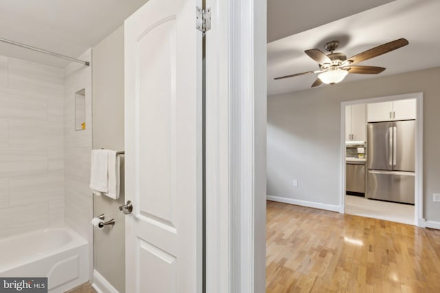 full bathroom with bathtub / shower combination, wood finished floors, a ceiling fan, and baseboards