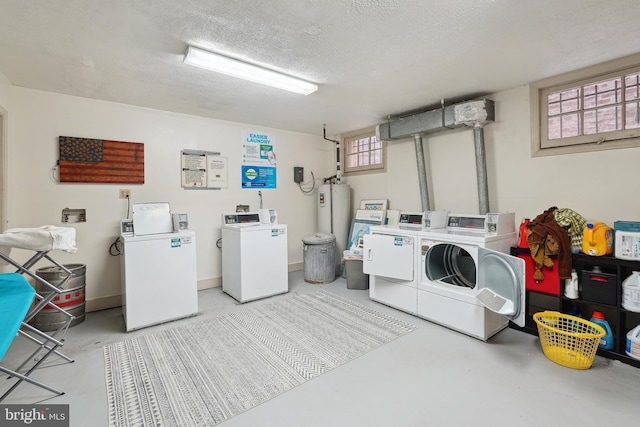 common laundry area featuring gas water heater, baseboards, a textured ceiling, and washing machine and dryer