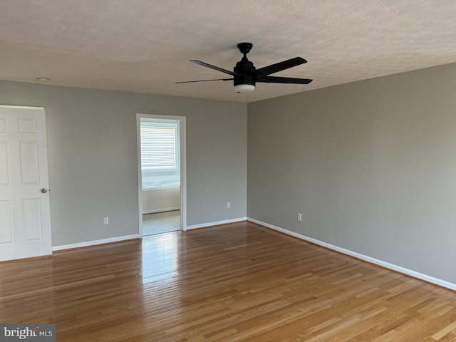 empty room with ceiling fan, light hardwood / wood-style flooring, and a textured ceiling