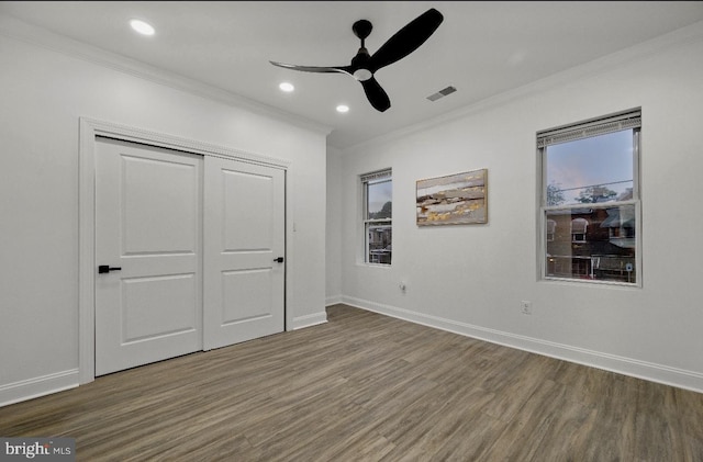 unfurnished bedroom with a closet, ceiling fan, ornamental molding, and hardwood / wood-style floors