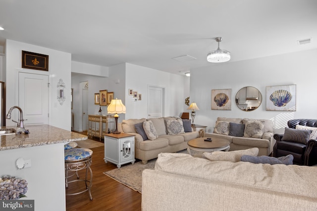 living room featuring sink and dark hardwood / wood-style flooring