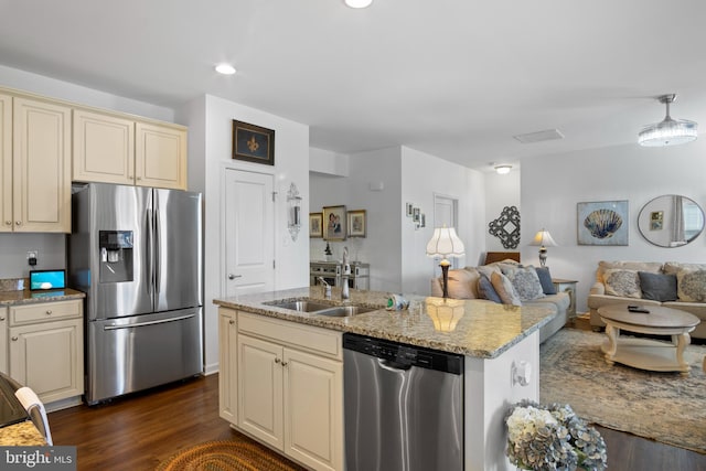 kitchen featuring cream cabinets, a center island with sink, dark hardwood / wood-style flooring, appliances with stainless steel finishes, and sink