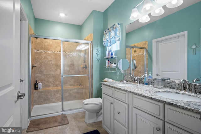 bathroom featuring vanity, a shower with shower door, toilet, and tile patterned floors