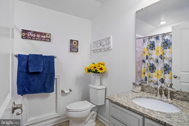 bathroom with toilet, lofted ceiling, and vanity