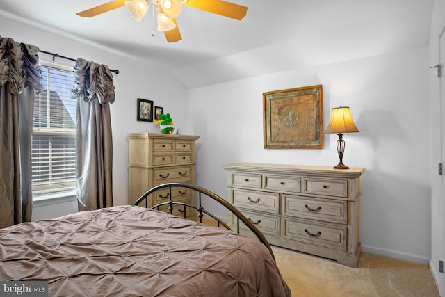 carpeted bedroom with ceiling fan and vaulted ceiling