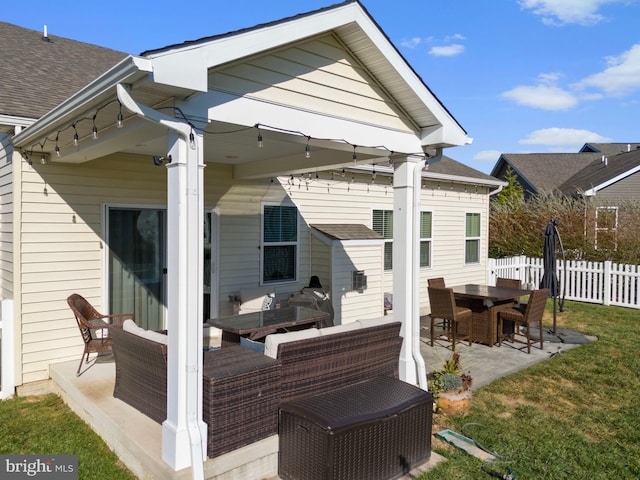 rear view of property with a patio and a lawn