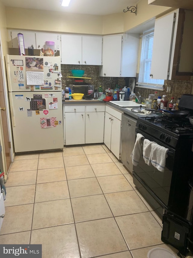 kitchen with gas stove, white cabinetry, sink, white refrigerator, and backsplash