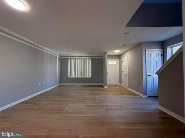 entrance foyer with light hardwood / wood-style floors and crown molding