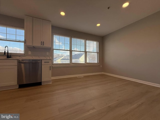 kitchen featuring a wealth of natural light, white cabinetry, and stainless steel dishwasher