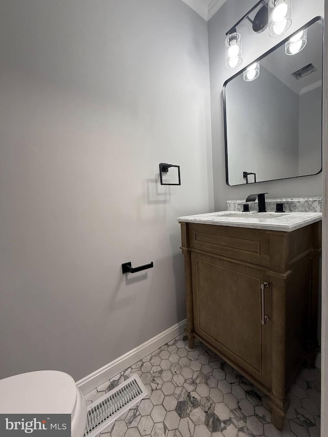 bathroom featuring tile patterned floors, crown molding, vanity, and toilet