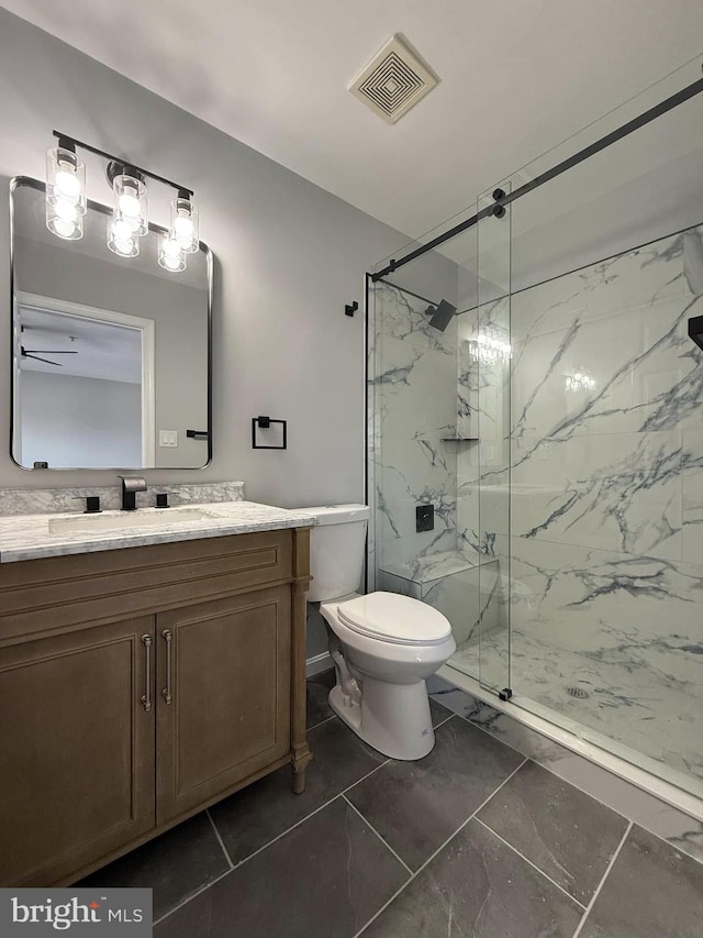 bathroom with vanity, a shower with shower door, and toilet