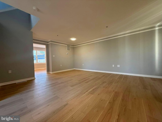 unfurnished room with light hardwood / wood-style flooring and ornamental molding