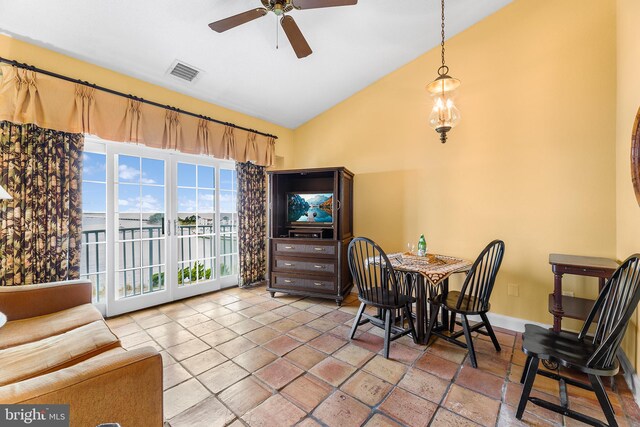 dining area featuring ceiling fan with notable chandelier and vaulted ceiling