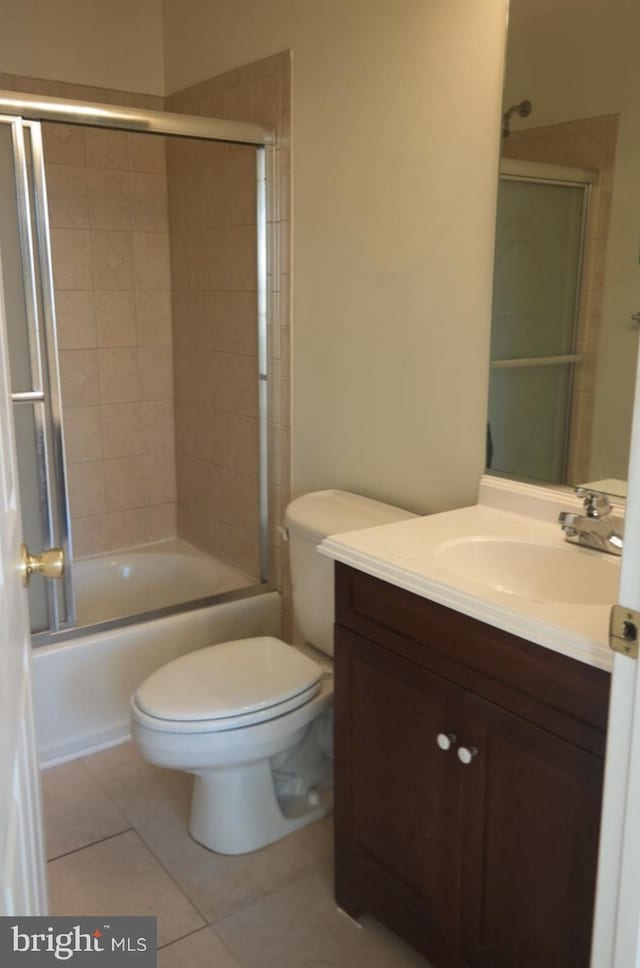 full bathroom featuring vanity, combined bath / shower with glass door, toilet, and tile patterned flooring