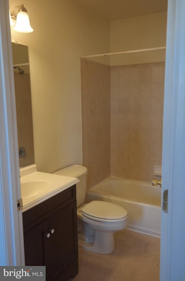 full bathroom with vanity, tiled shower / bath, toilet, and tile patterned flooring