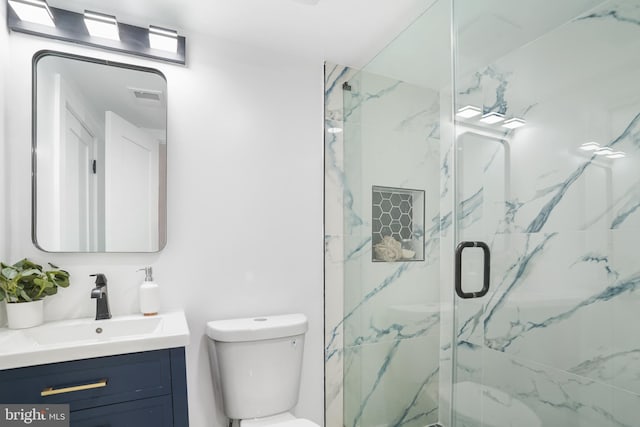 bathroom featuring toilet, an enclosed shower, and vanity