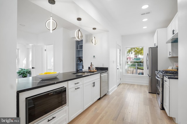 kitchen with pendant lighting, light wood-type flooring, appliances with stainless steel finishes, and sink