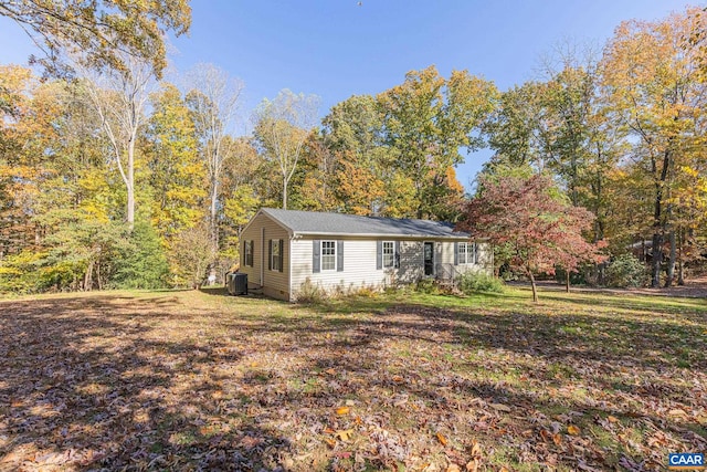 single story home featuring central air condition unit and a front lawn