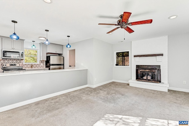 unfurnished living room featuring light carpet, a fireplace, and ceiling fan