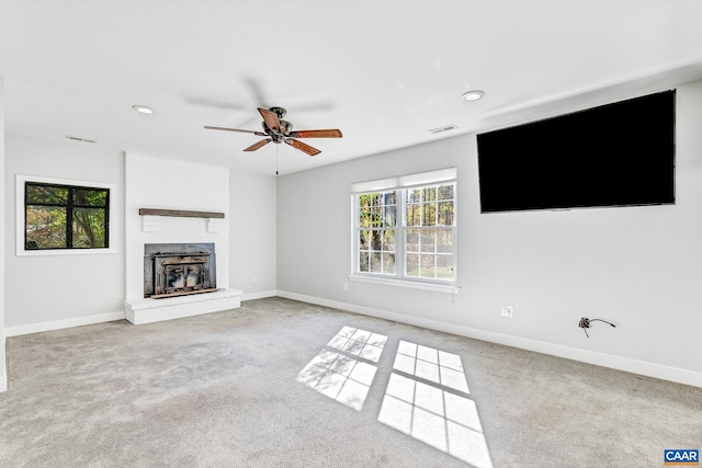 unfurnished living room with light carpet, a fireplace, and ceiling fan