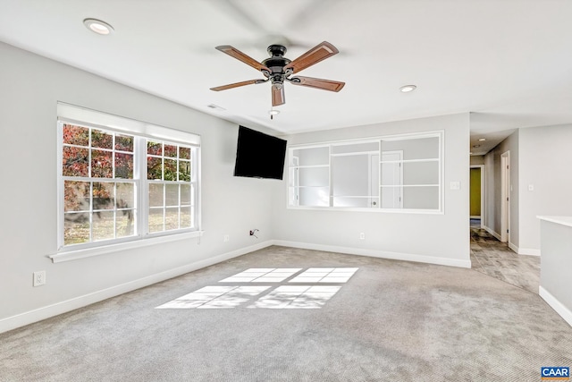 spare room featuring ceiling fan and light colored carpet