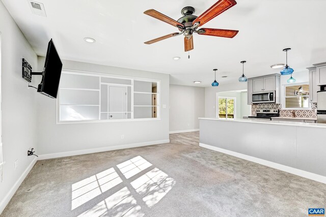 unfurnished living room featuring light colored carpet and ceiling fan