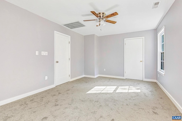 carpeted spare room with ceiling fan