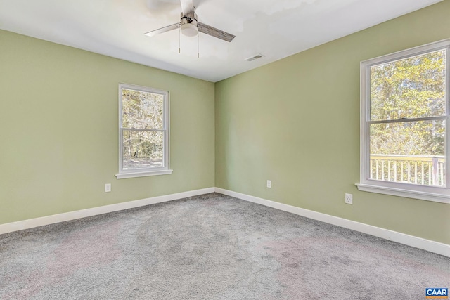 carpeted empty room featuring a wealth of natural light and ceiling fan