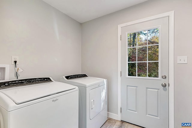 washroom featuring washer and clothes dryer and light hardwood / wood-style flooring