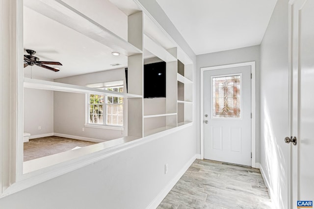 foyer with ceiling fan and light wood-type flooring