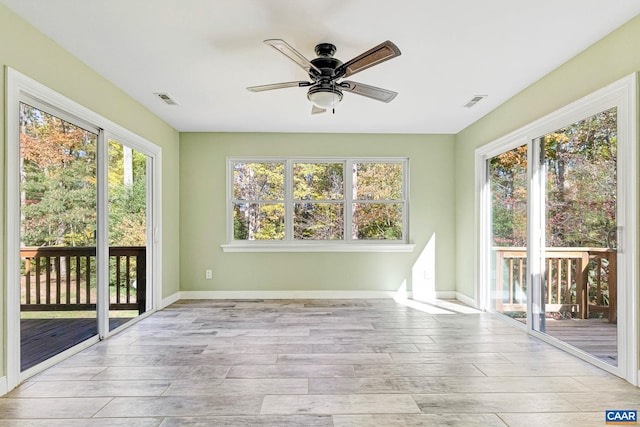 unfurnished sunroom featuring ceiling fan