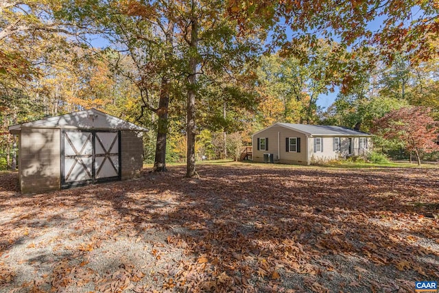 view of yard featuring a storage shed and central AC unit