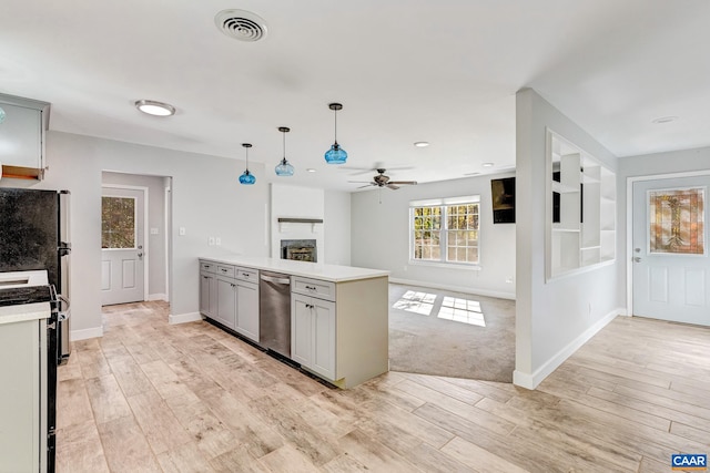 kitchen featuring decorative light fixtures, gray cabinetry, stainless steel appliances, and light wood-type flooring