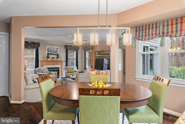 dining area featuring a textured ceiling, dark wood-type flooring, and a notable chandelier