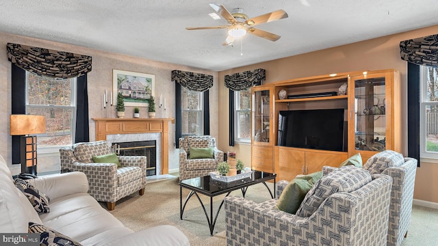 carpeted living room with a textured ceiling, ceiling fan, and a premium fireplace