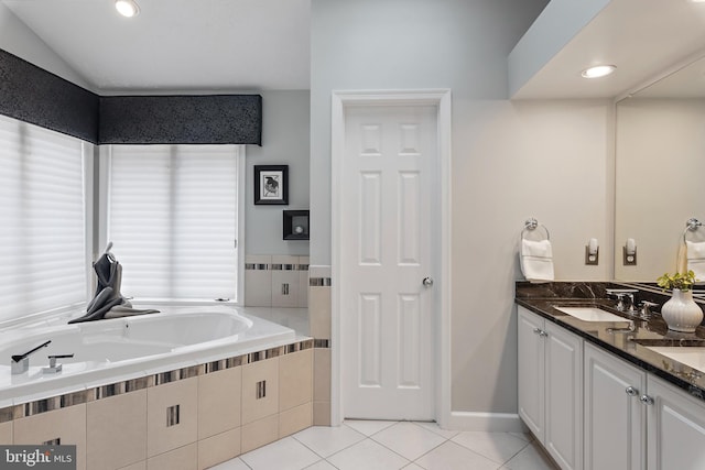 bathroom with tile patterned floors, vanity, and tiled tub