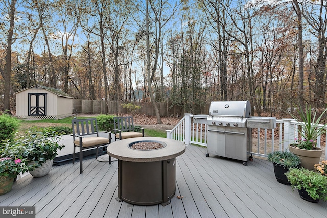 deck with area for grilling, a storage unit, and an outdoor fire pit