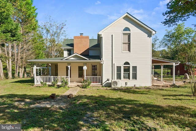 back of property featuring covered porch, a lawn, and ac unit